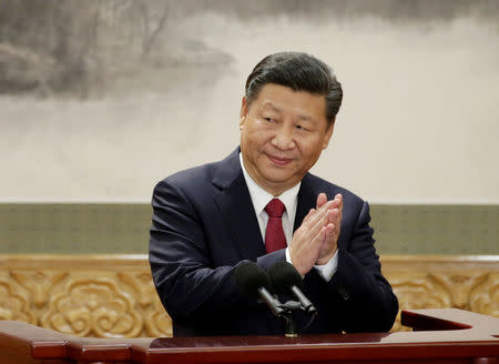 FILE PHOTO: China's President Xi Jinping claps after his speech as he and other new Politburo Standing Committee members meet with the press at the Great Hall of the People in Beijing, China October 25, 2017. REUTERS/Jason Lee/File Photo