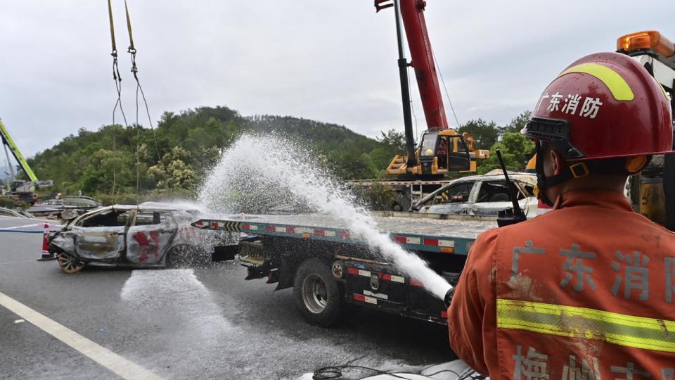 Water sprayed on the remains of a car recovered after a road collapse