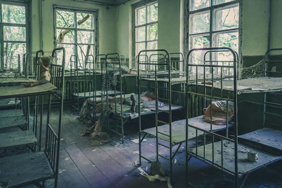 <p>Rows of empty bunk beds line the walls of this abandoned mental facility.</p>