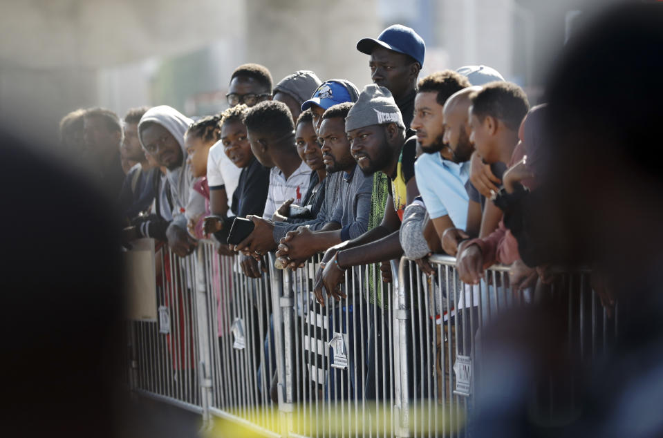 People wait to apply for asylum in the United States along the border Tuesday, July 16, 2019, in Tijuana, Mexico. Dozens of immigrants lined up Tuesday at a major Mexico border crossing, waiting to learn how the Trump administration's plans to end most asylum protections would affect their hopes of taking refuge in the United States. (AP Photo/Gregory Bull)