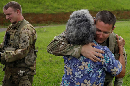 UH-60 Blackhawk helicopter pilot Chris Greenway receives a hug from a woman thanking him for water as he works with the First Armored Division's Combat Aviation Brigade during recovery efforts following Hurricane Maria, in Verde de Comerio, Puerto Rico, October 7, 2017. REUTERS/Lucas Jackson