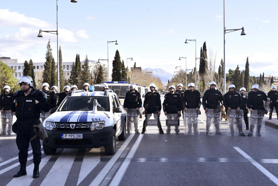 Police officers guard the parliament building in Podgorica, Montenegro, Thursday, Dec. 26, 2019, during a protest against a proposed law regarding religious communities and property. The Serbian Orthodox Church says the law will strip it of its property, including medieval monasteries and churches. The government has denied that. (AP Photo/Risto Bozovic)