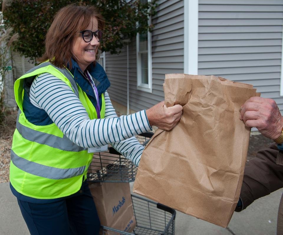 Volunteer Tara Roselli delivers Thanksgiving meal fixings at Open Table in Maynard, where hundreds of Thanksgiving dinners were prepared a day earlier, Nov. 14, 2023.