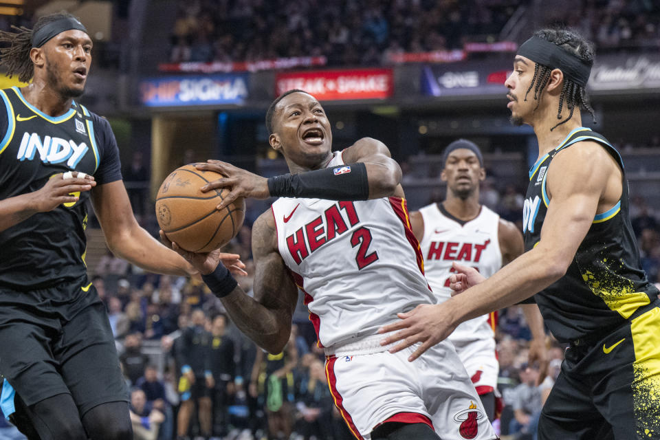 Miami Heat guard Terry Rozier (2) shoots while being defended by Indiana Pacers center Myles Turner, left, and guard Andrew Nembhard (2) during the first half of an NBA basketball game in Indianapolis, Sunday, April 7, 2024. (AP Photo/Doug McSchooler)