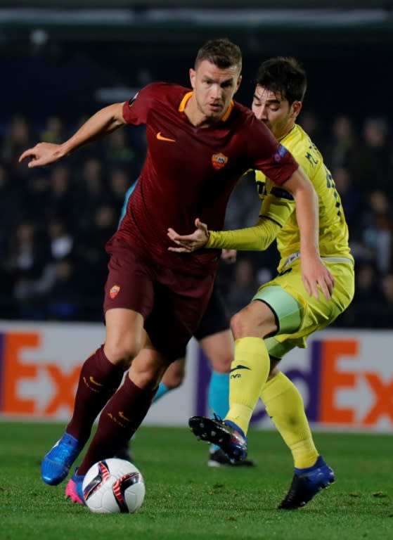 Roma's Edin Dzeko (L) fights for the ball with Villarreal's Manu Trigueros during their UEFA Europa League round of 32 first leg match, at El Ceramica stadium in Vila-real, Spain, on February 16, 2017