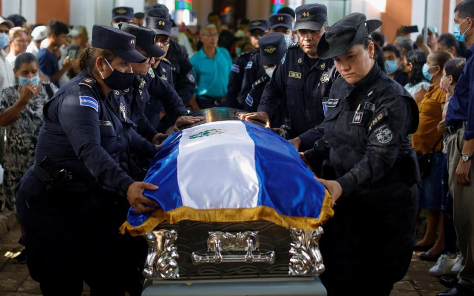 Police officers carry the coffin of fellow officer Carlos Velasquez, covered with El Salvador's flag - Jose Cabezas/REUTERS