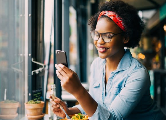 A woman checks her smartphone.