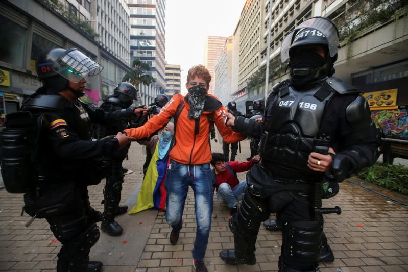 Policías arrestan a un joven manifestante durante las protestas en Bogotá