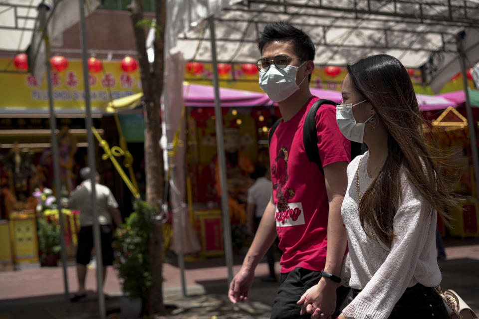 SINGAPORE, SINGAPORE - FEBRUARY 28: A couple wearing masks walk on the paveway at Waterloo area on February 28, 2020 in Singapore. The coronavirus, originating in Wuhan, China has spread to over 80,000 people globally, more than 50 countries have now been infected.  (Photo by Ore Huiying/Getty Images)