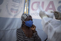 A woman who is HIV-positive receives her antiretroviral drugs inside a gazebo used as a mobile clinic in Ngodwana, South Africa, Thursday, July 2, 2020. Across Africa and around the world, the COVID-19 pandemic has disrupted the supply of antiretroviral drugs to many of the more than 24 million people who take them, endangering their lives. An estimated 7.7 million people in South Africa are HIV positive, the largest number in the world, and 62% of them take the antiretroviral drugs that suppress the virus and prevent transmission. (AP Photo/Bram Janssen)