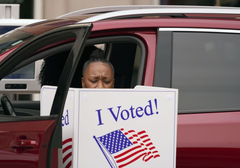 Una mujer emite su voto el jueves 15 de octubre de 2020, desde su vehículo durante el periodo de votación anticipada de Texas, en Dallas. (AP Foto/LM Otero)