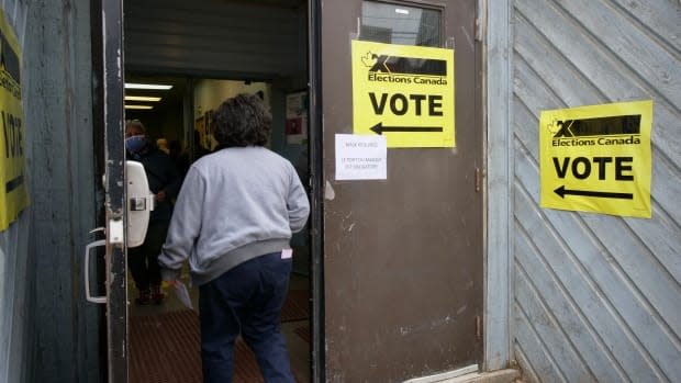 A polling station in Iqaluit for Monday's federal election. Signs asking that voters wear masks were posted in English and French, but not Inuktitut.  (Matisse Harvey/Radio-Canada - image credit)