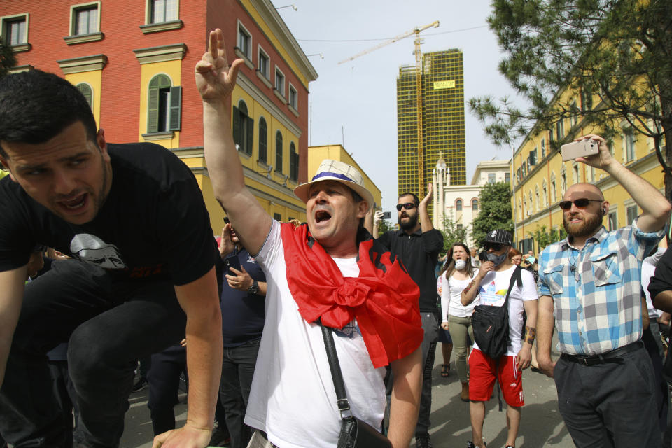 Protesters shout slogans during the demolition of the national theater building in Tirana, Sunday, May 17, 2020. The government's decision to destroy the old National Theater, built by Italians when they occupied Albania during World War II, was opposed by artists and others who wanted it renovated instead. (AP Photo/Gent Onuzi)