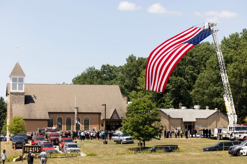 An American flag flies off a fire truck at Cabot United Methodist church Friday, July 19th for the funeral of Corey Comperatore the Buffalo Township man killed at SaturdayÕs rally for former President Donald Trump from a would-be assassinÕs stray bullet. Kevin Whitlock / Massillon Independent
Published Image