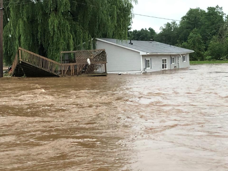 A house, and what appears to be a deck from another home, were damaged in the flooding in Windsor, N.S.