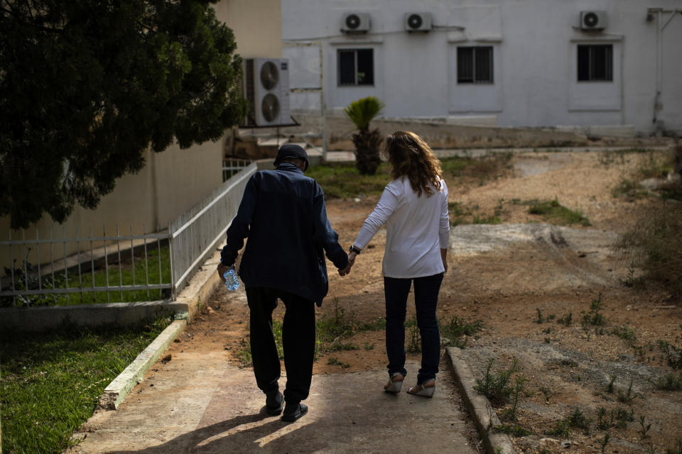 Abu Omar, 81, walks hand in hand with an assistant at the Social Services Medical Association, a rehabilitation hospital and nursing home in the northern city of Tripoli, Lebanon, Thursday, June 10, 2021. Lebanon is one of only 16 countries in the world with no pension scheme for private sector workers in case of old age, disability and death, according to the ILO. The national social security program covers only 30% of the labor force, mainly giving one-time payments at retirement, and is dangerously underfunded. (AP Photo/Hassan Ammar)