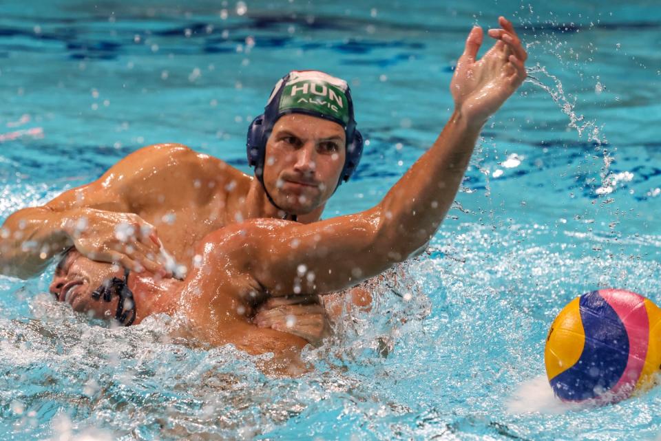 One player pushes another down in a water polo match at the Tokyo Olympics.