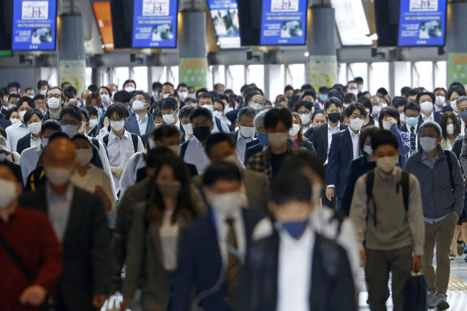 Commuters wearing face masks walk through a station passageway in Tokyo Friday, May 7, 2021. Japan is set to expand and extend a state of emergency in Tokyo and other areas through May 31 as the coronavirus continues spreading and uncertainty grows about safely holding the Olympics just 11 weeks away. (Yuta Omori/Kyodo News via AP)