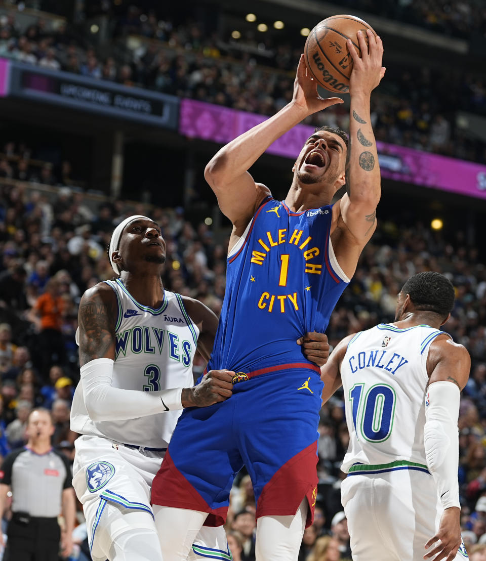 Denver Nuggets forward Michael Porter Jr., right, is fouled on the way to the net by Minnesota Timberwolves forward Jaden McDaniels in the first half of an NBA basketball game Friday, March 29, 2024, in Denver. (AP Photo/David Zalubowski)