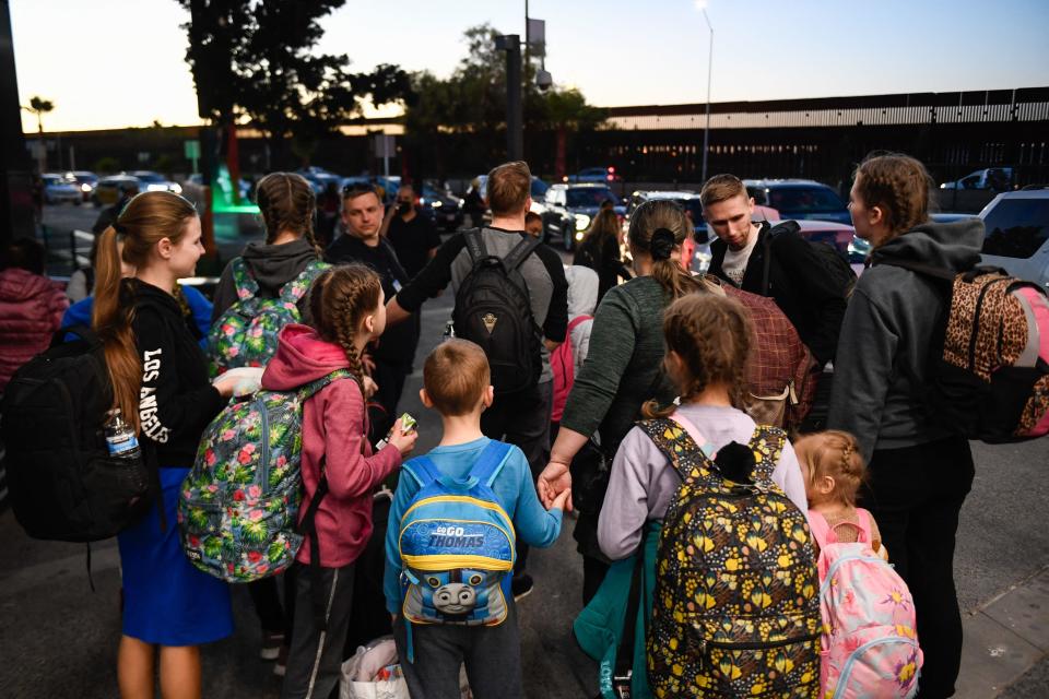 A family of a dozen Ukrainian refugees waits to be transported after arriving at the Tijuana airport, where they are met by volunteers who are helping them on their journey to the US after fleeing the war in Ukraine, in Tijuana, Baja California, Mexico, April 8, 2022. / Credit: PATRICK T. FALLON/AFP via Getty Images