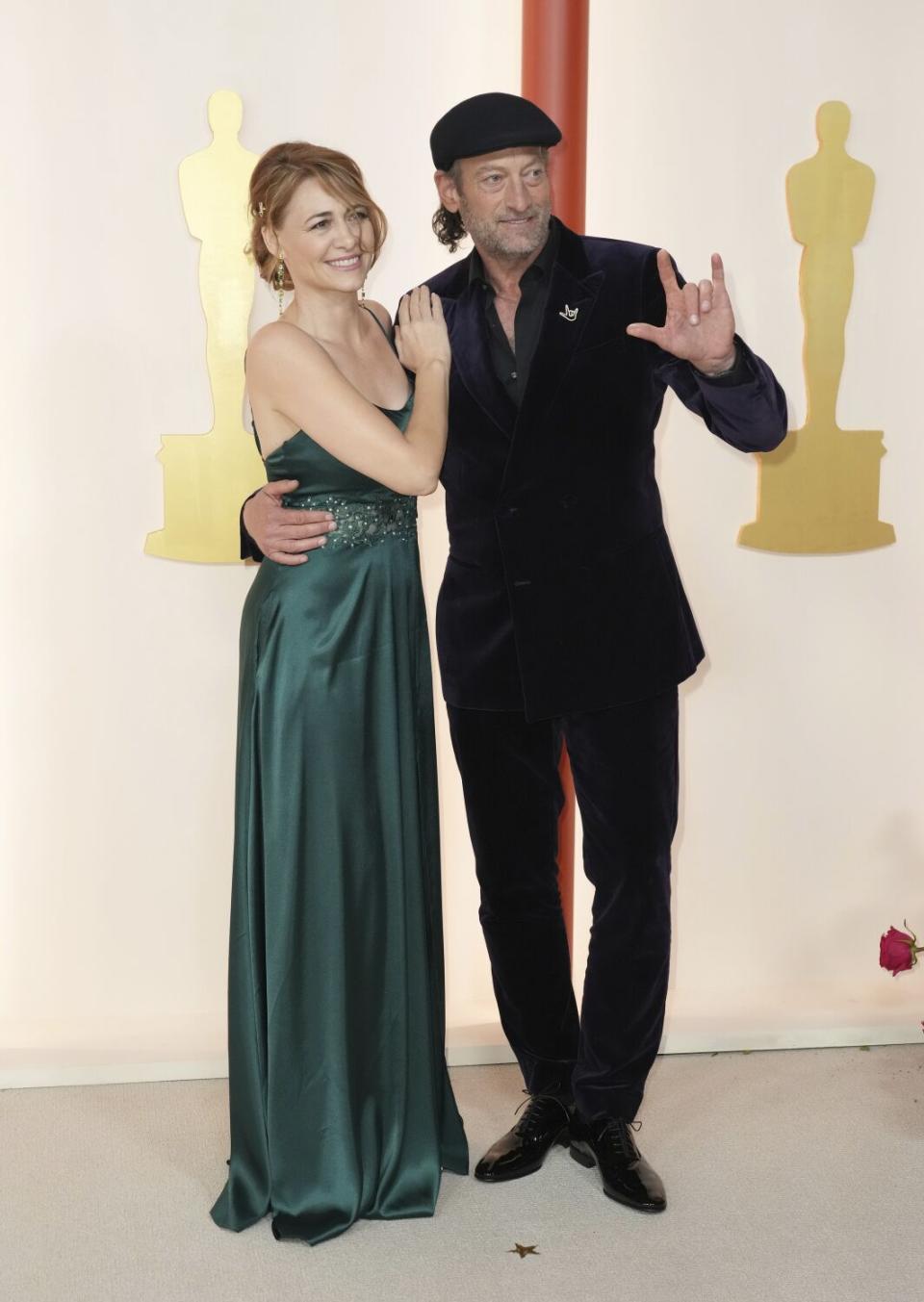 Deanne Bray, izquierda, y el actor Troy Kotsur, posan en la alfombra champán.