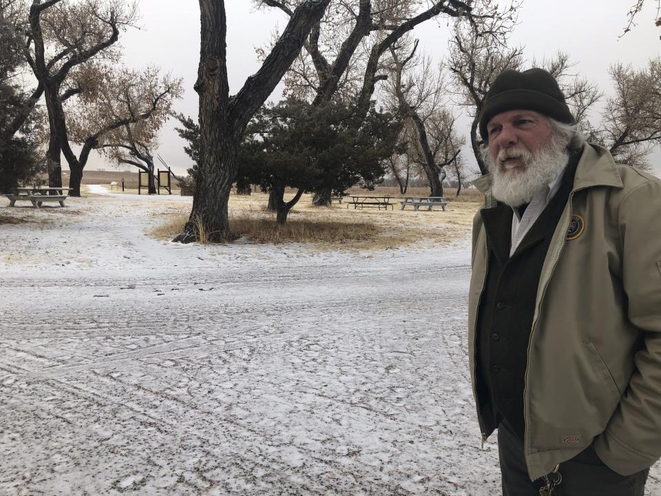 In this Dec. 27, 2019, photo, Jeff C. Campbell, a volunteer ranger at the Sand Creek Massacre National Historic Site in Eads, Colo., speaks about the history of the site. This quiet piece of land tucked away in rural southeastern Colorado seeks to honor the 230 peaceful Cheyenne and Arapaho tribe members who were slaughtered by the U.S. Army in 1864. It was one of worst mass murders in U.S. history. (AP Photo/Russell Contreras)