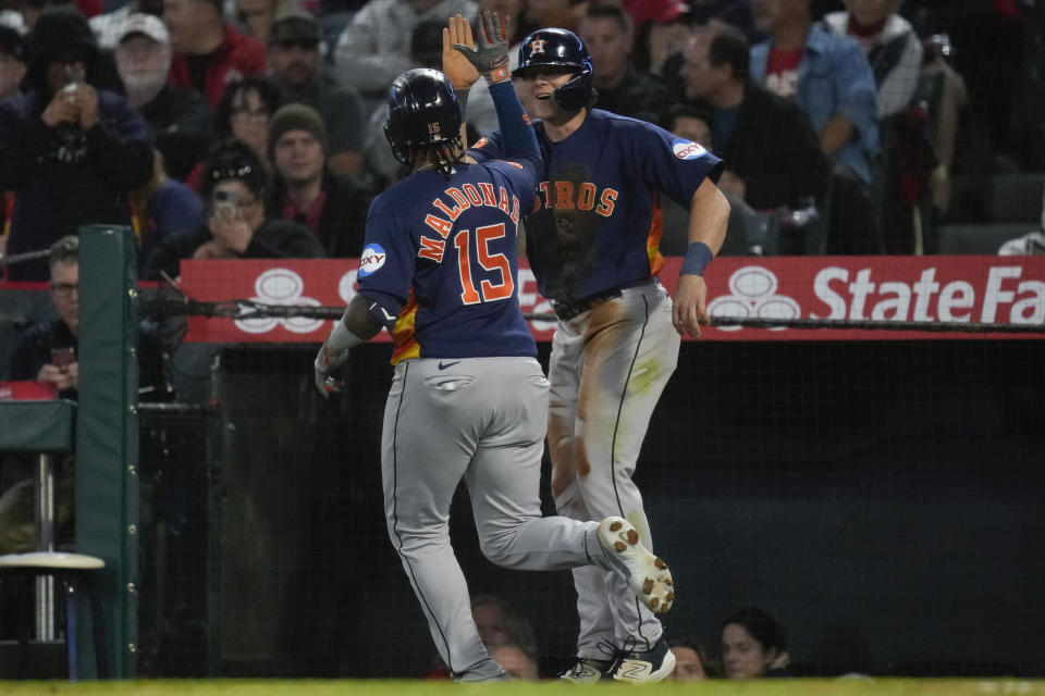 Houston Astros' Martin Maldonado (15) celebrates with Jake Meyers after they both scored off of a home run hit by Maldonado during the fifth inning of a baseball game against the Los Angeles Angels in Anaheim, Calif., Tuesday, May 9, 2023. (AP Photo/Ashley Landis)