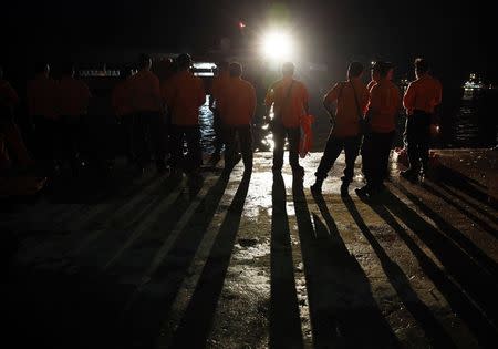 Search and Rescue team members stand by as they get ready to board SAR ship Purworejo for search operations for passengers onboard AirAsia flight QZ8501 at Kumai port, Pangkalan Bun district December 31, 2014. REUTERS/Beawiharta