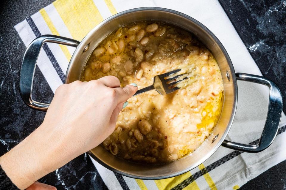 Use a potato masher or the back of a fork to crush the beans until mostly mashed (Rey Lopez/Washington Post)