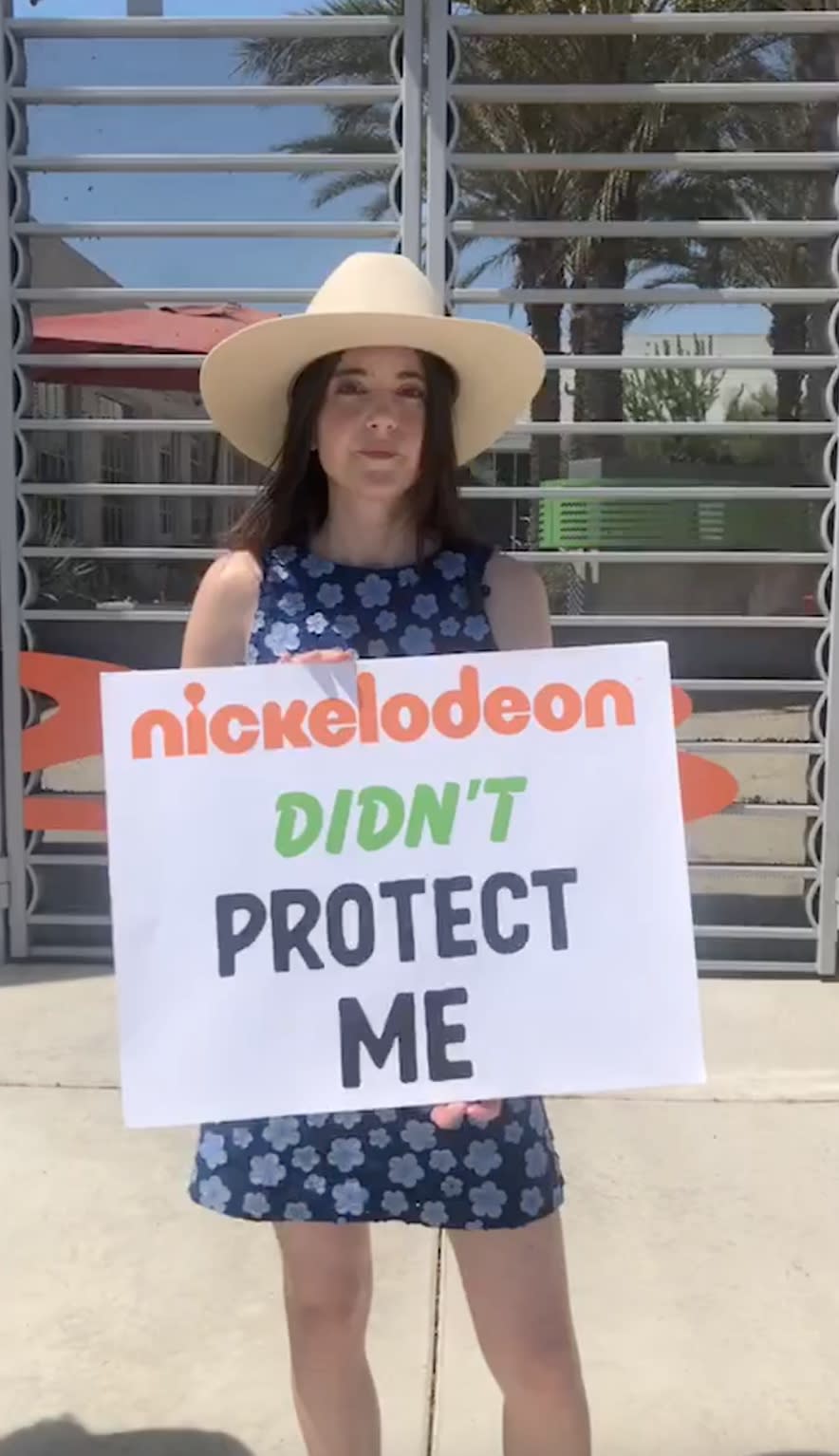 Alexa Nikolas holding a sign that says Nickelodeon didn't protect me