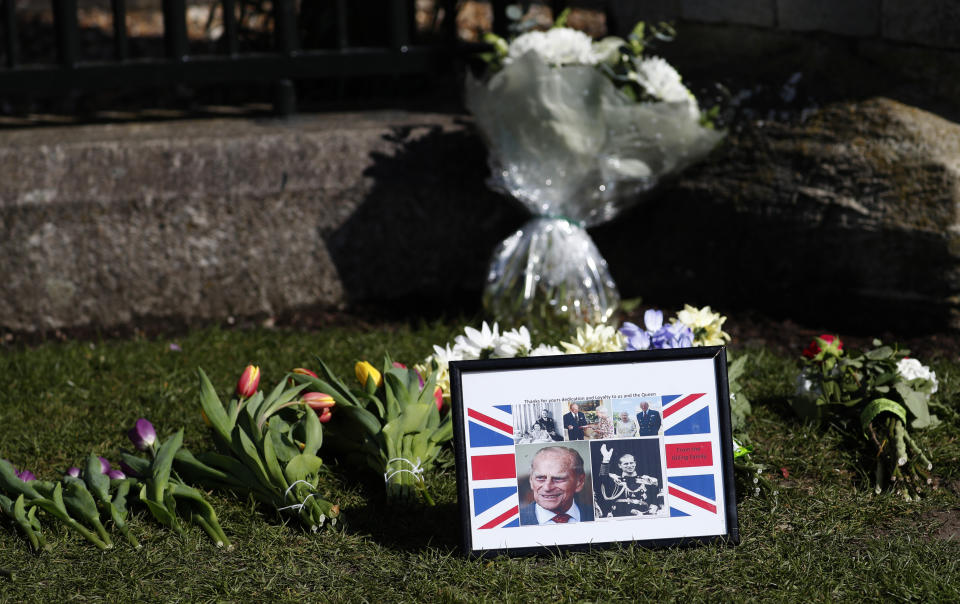 Tributes are laid outside Windsor Castle Windsor, England, Tuesday, April 13, 2021. Britain's Prince Philip, husband of Queen Elizabeth II, died Friday April 9 aged 99. His funeral service will take place on Saturday at Windsor Castle. (AP Photo/Alastair Grant)