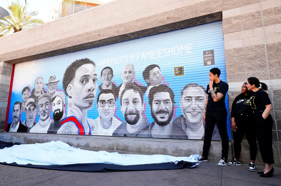 Phoenix Mercury star Brittney Griner views the faces after unveiling a mural outside of Footprint Center in Phoenix on April 27, 2023, that brings awareness to individuals still detained abroad.