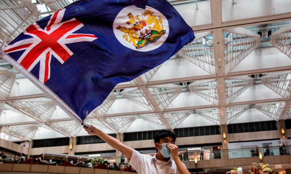 A pro-democracy protester waves a British colonial flag during a rally on 1 June.