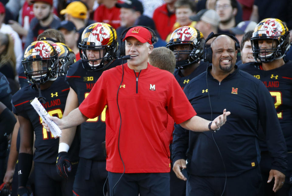 In this Oct. 14, 2017, file photo, Maryland head coach DJ Durkin, center, stands on the sideline in the first half of an NCAA college football game against Northwestern in College Park, Md. The Atlanta Falcons have brought in former Maryland coach DJ Durkin to serve as a guest coach during training camp, drawing immediate scrutiny over the wisdom of taking on someone who was fired from his previous job after a player's death. This is the first coaching stint for Durkin since he was dismissed by the Terrapins last October. (AP Photo/Patrick Semansky, File)