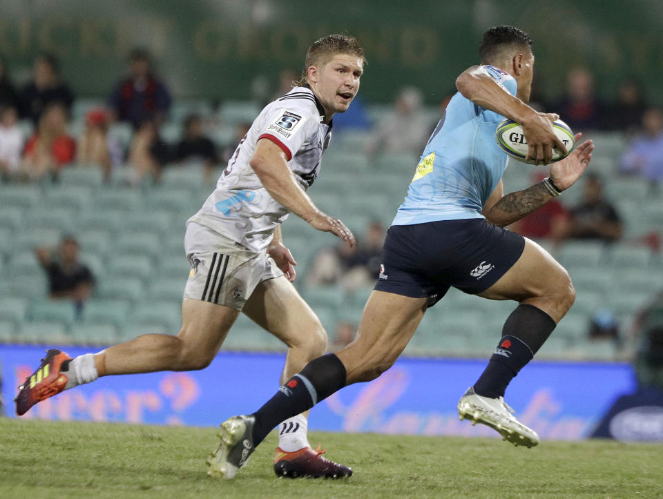 The Waratahs' Israel Folau, right, tries to go around Crusaders' Jack Goodhue during their Super Rugby game in Sydney, Australia, Saturday, March 23, 2019. (AP Photo/Rick Rycroft)