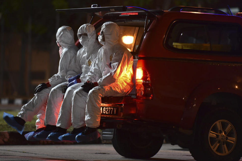 In this photo taken and released by Malaysia's Ministry of Health, health workers wearing full protective suits sit on a vehicle as they wait for the arrival of evacuated Malaysian from China's Wuhan, the epicenter of the coronavirus outbreak, at Kuala Lumpur International Airport in Sepang, Malaysia, Wednesday, Feb. 26, 2020. U.S. health officials warned Tuesday that the burgeoning coronavirus is certain to spread more widely in the country at some point, even as their counterparts in Europe and Asia scrambled to contain new outbreaks of the illness. (Muzzafar Kasim/Malaysia's Ministry of Health via AP)