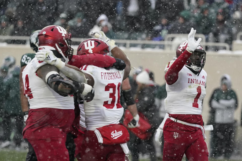 Indiana team members hug Indiana defensive back Bryant Fitzgerald (31) after the second overtime of an NCAA college football game against Michigan State, Saturday, Nov. 19, 2022, in East Lansing, Mich. (AP Photo/Carlos Osorio)