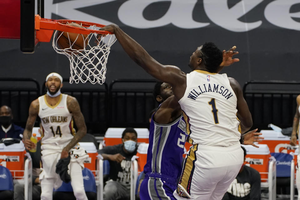 New Orleans Pelicans forward Zion Williamson, right, dunks over Sacramento Kings forward Chimezie Metu during the first quarter of an NBA basketball game in Sacramento, Calif., Sunday, Jan.17, 2021. (AP Photo/Rich Pedroncelli)