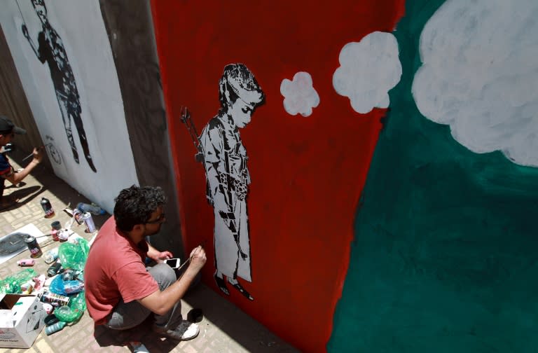 Yemeni artists work on a mural as part of a campaign to end the recruitment of child soldiers by tribal militias, in the capital Sanaa, in 2014