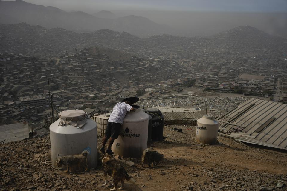 Alfonso Tapullima looks into an empty water container in the Pamplona Alta area in Lima, Peru, Thursday, March 7, 2024. (AP Photo/Martin Mejia)