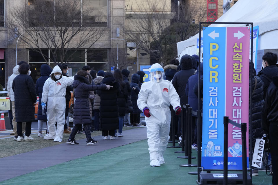Medical workers guide people as they wait for their coronavirus tests outside a public health center in Seoul, South Korea, Thursday, Feb. 17, 2022. (AP Photo/Ahn Young-joon)