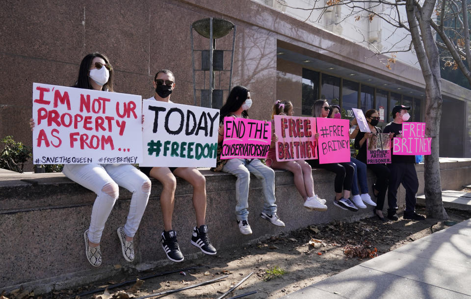 Britney Spears supporters sit together outside a court hearing concerning the pop singer's conservatorship at the Stanley Mosk Courthouse, Thursday, Feb. 11, 2021, in Los Angeles. (AP Photo/Chris Pizzello)