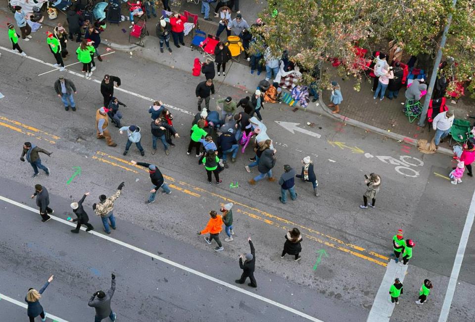 People rush to attempt to aid the victim, a young member of a dance troupe, after she was struck by a truck pulling a float of other dancers during the Raleigh Christmas Parade, Sunday, Nov. 19, 2022.
