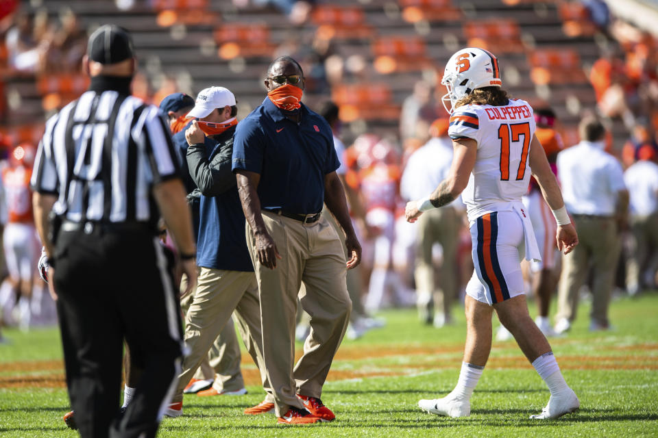 Syracuse head coach Dino Babers, center, and quarterback Rex Culpepper walk on the field before an NCAA College football game against Clemson in Clemson, S.C., on Saturday, Oct. 24, 2020. (Ken Ruinard/Pool Photo via AP)