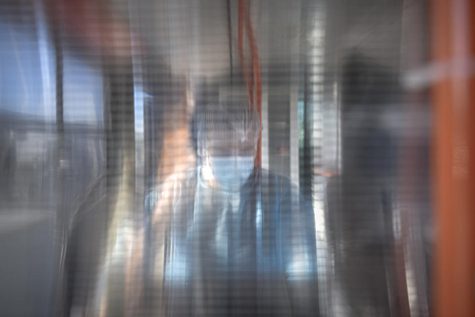 FILE - A medical worker is seen through a plastic panel in a bus that will serve as a mobile COVID-19 vaccination unit in Bucharest, Romania, Saturday, Sept. 4, 2021. (AP Photo/Andreea Alexandru, File)