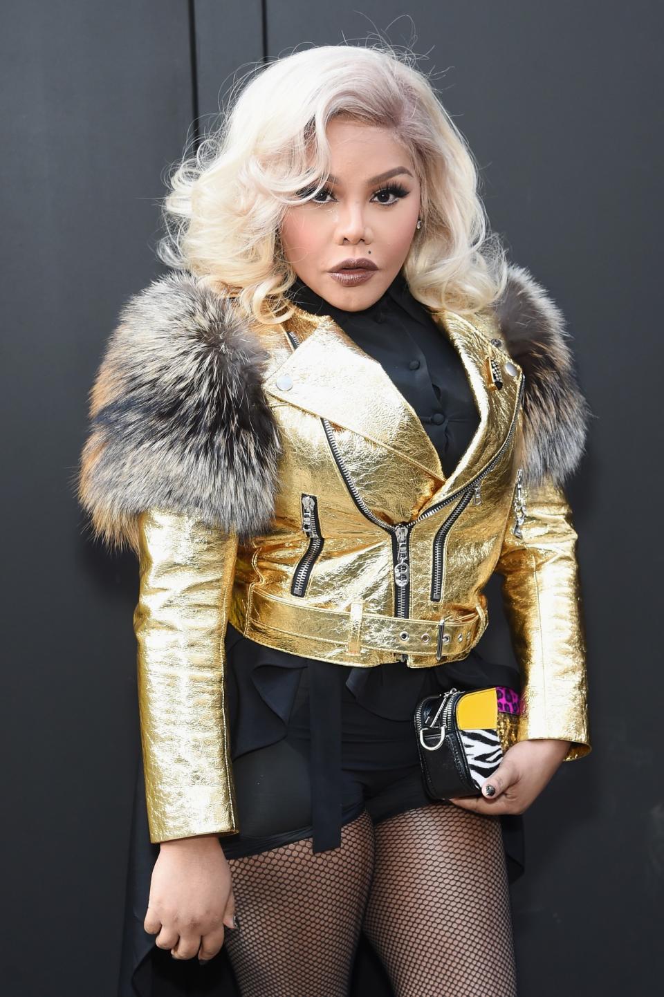 Lil Kim rocks her platinum blond locks and golden, fur-lined bomber to the Marc Jacobs Fall/Winter 2017 show