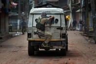 <p>An Indian policeman takes cover behind an armored vehicle as Kashmiri protesters throw stones at him during a protest in Srinagar, Indian-controlled Kashmir on Aug. 30, 2016. (AP Photo/Dar Yasin) </p>