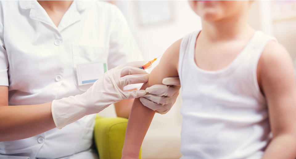 A doctor giving a young boy a vaccine. 