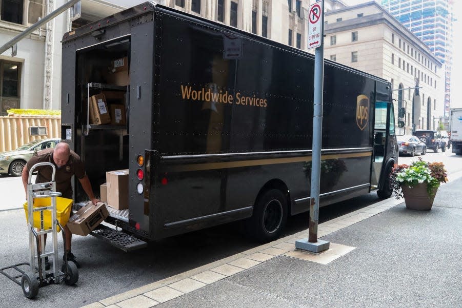 UPS driver putting packages in a UPS truck