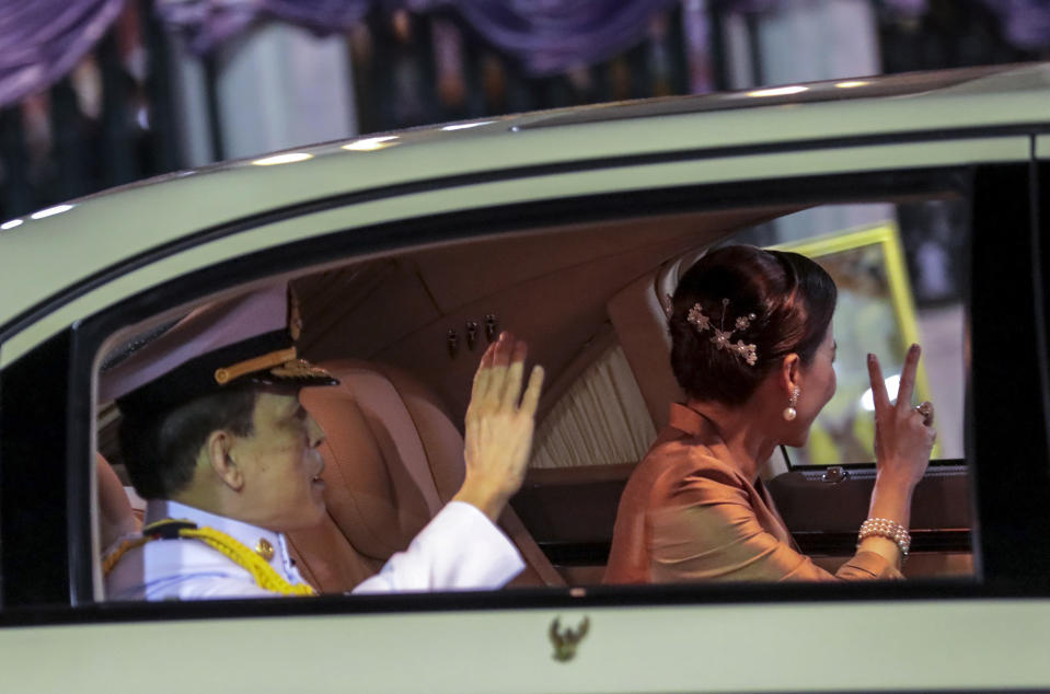 Thailand's King Maha Vajiralongkorn, left and Queen Suthida wave from a limousine after officiating a graduation ceremony at Thammasat University in Bangkok, Thailand, Saturday, Oct. 31, 2020. Thailand’s king has presided over a university graduation ceremony at a stronghold of a protest movement seeking to reduce the monarchy’s powers, after activists issued a call for students to boycott the event. (AP Photo/Sunti Teapia)